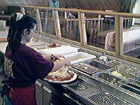 Heaping mozzarella cheese onto the pizza