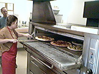 Removing the finished pizza from the oven