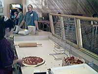 Ladling sauce onto the pizza crust